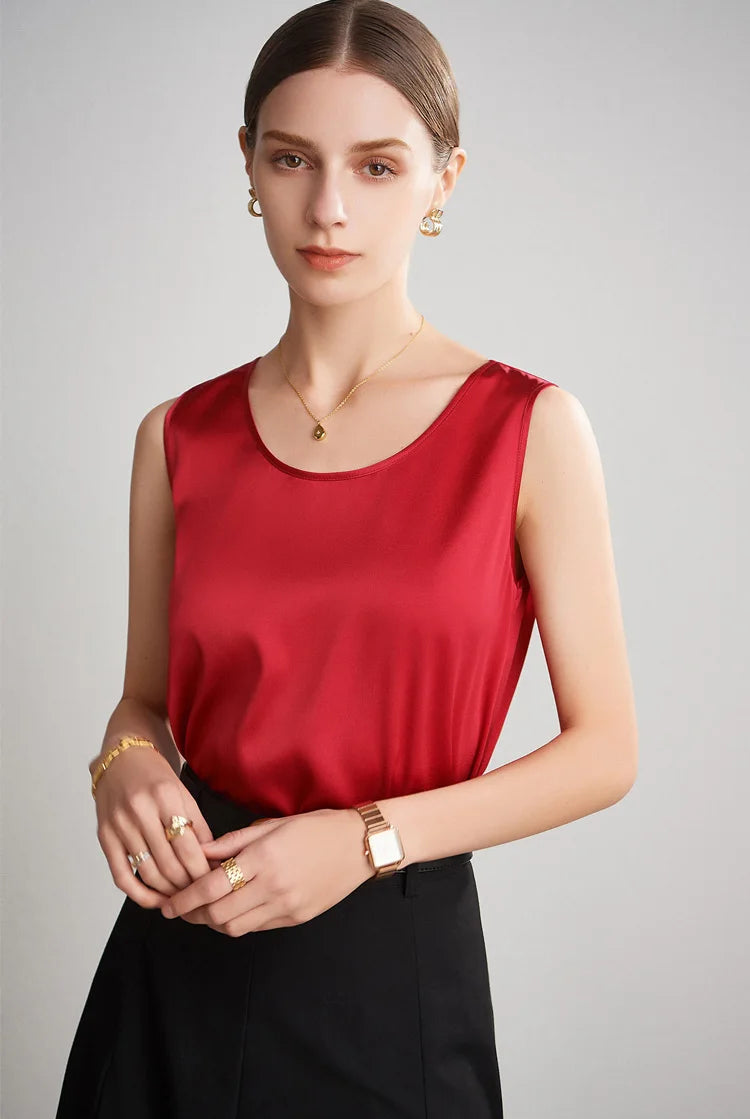 A woman wearing a red sleeveless silk top on a gray background