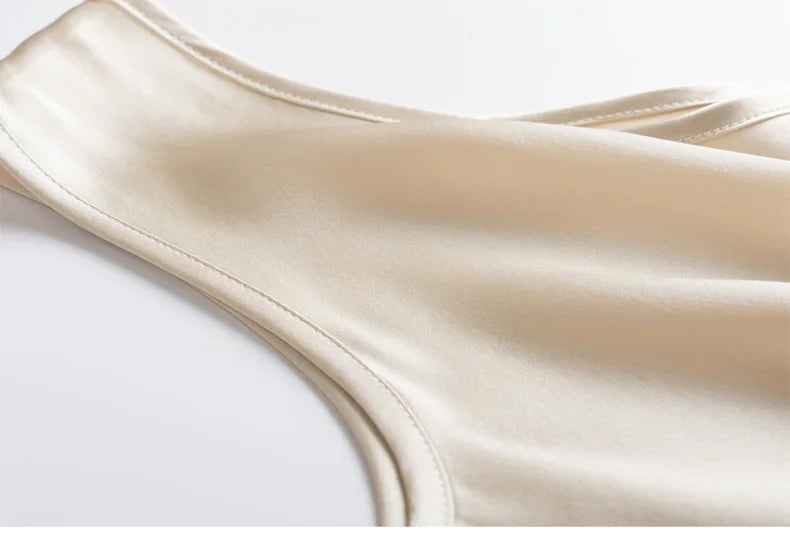 Close-up of a beige sleeveless silk top on a white background